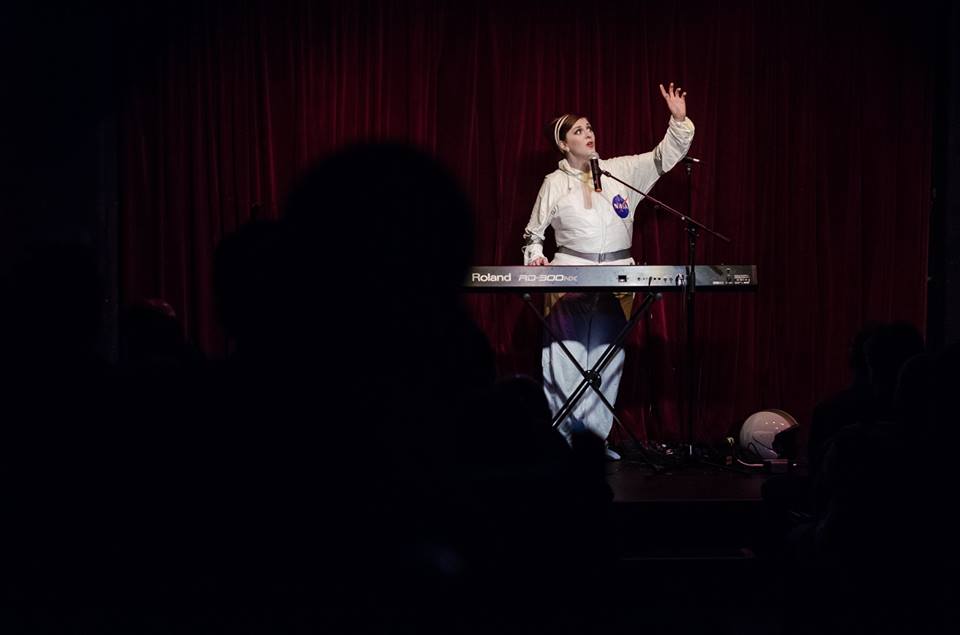 Me and the back of an audience member's head during To The Moon & Back at MICF. Photo by Brett Scapin Photography