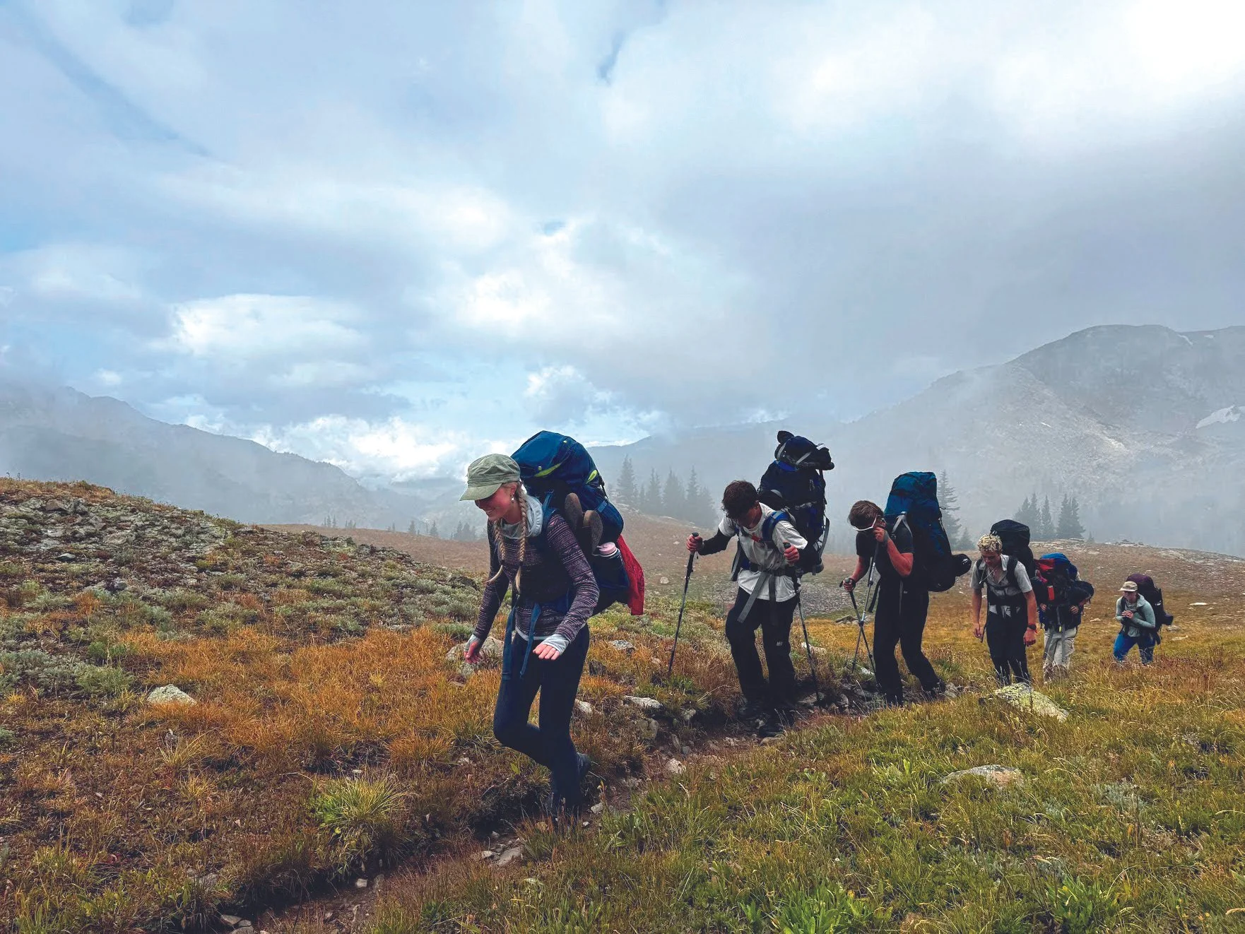 Watershed students backpacking across an alpine meadow on a fieldwork expedition