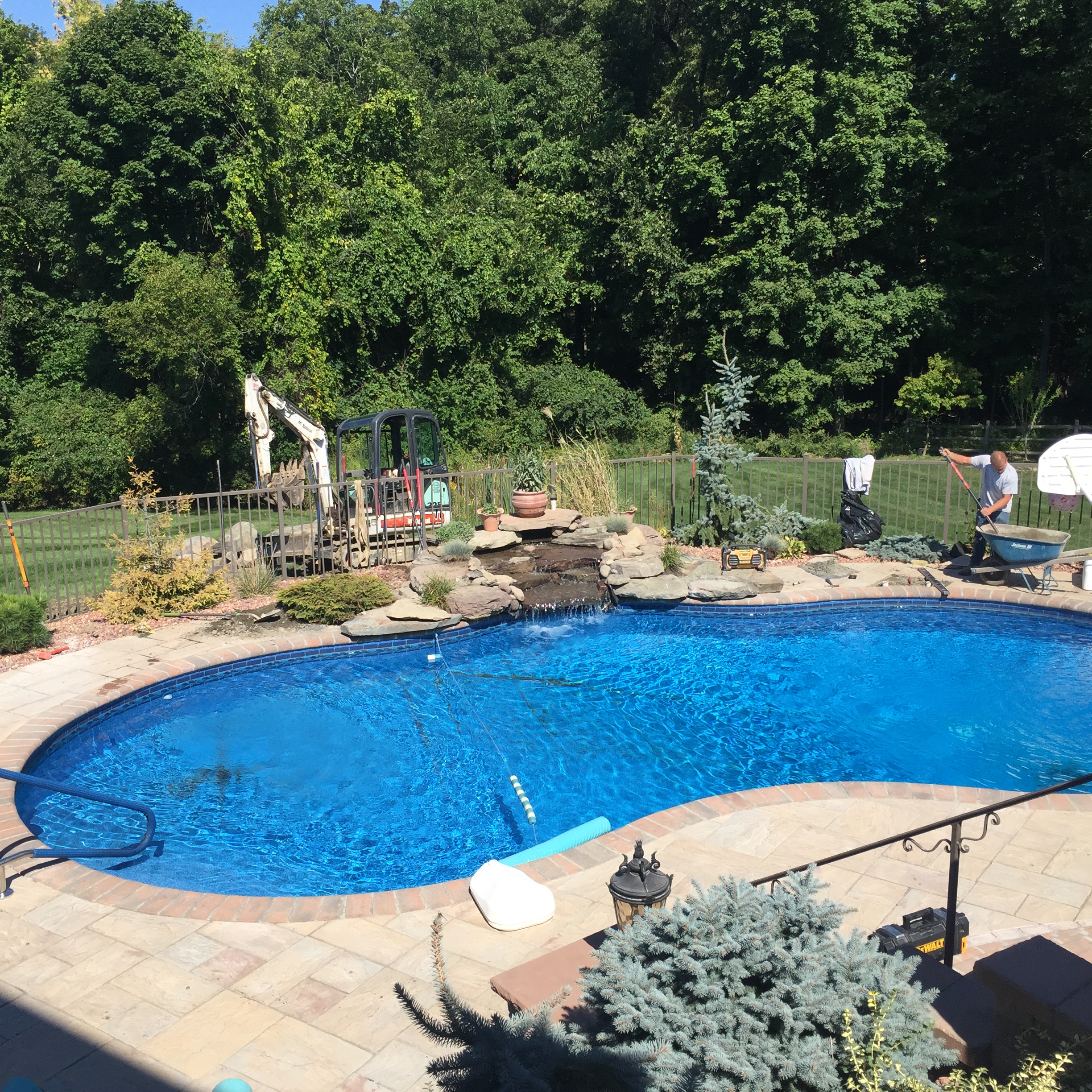 The Harmony Hill Team putting the finishing touches on this waterfall into a pool. 