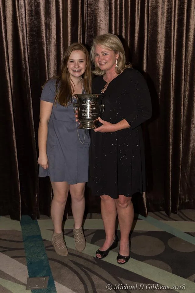 Amy and Kate posing with Amy's Outstanding Parent Award. 