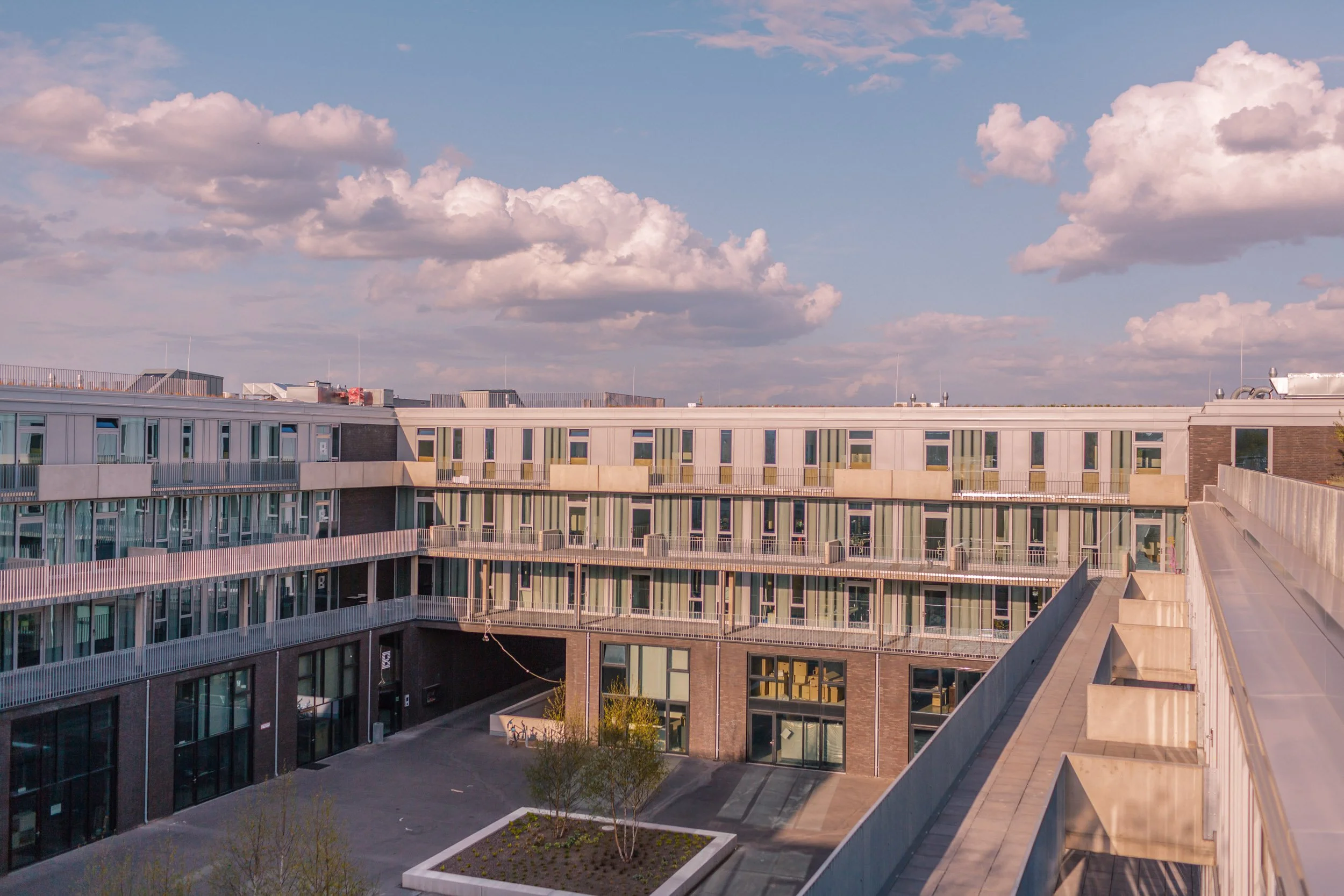 Moderne Wohngebäude mit mehreren Etagen und Balkonen, unter einem Himmel mit weißen Wolken.