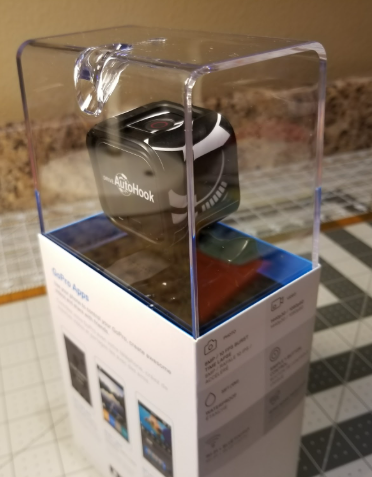 A black Fitbit Ace 3 activity tracker in display case on top of its packaging box.