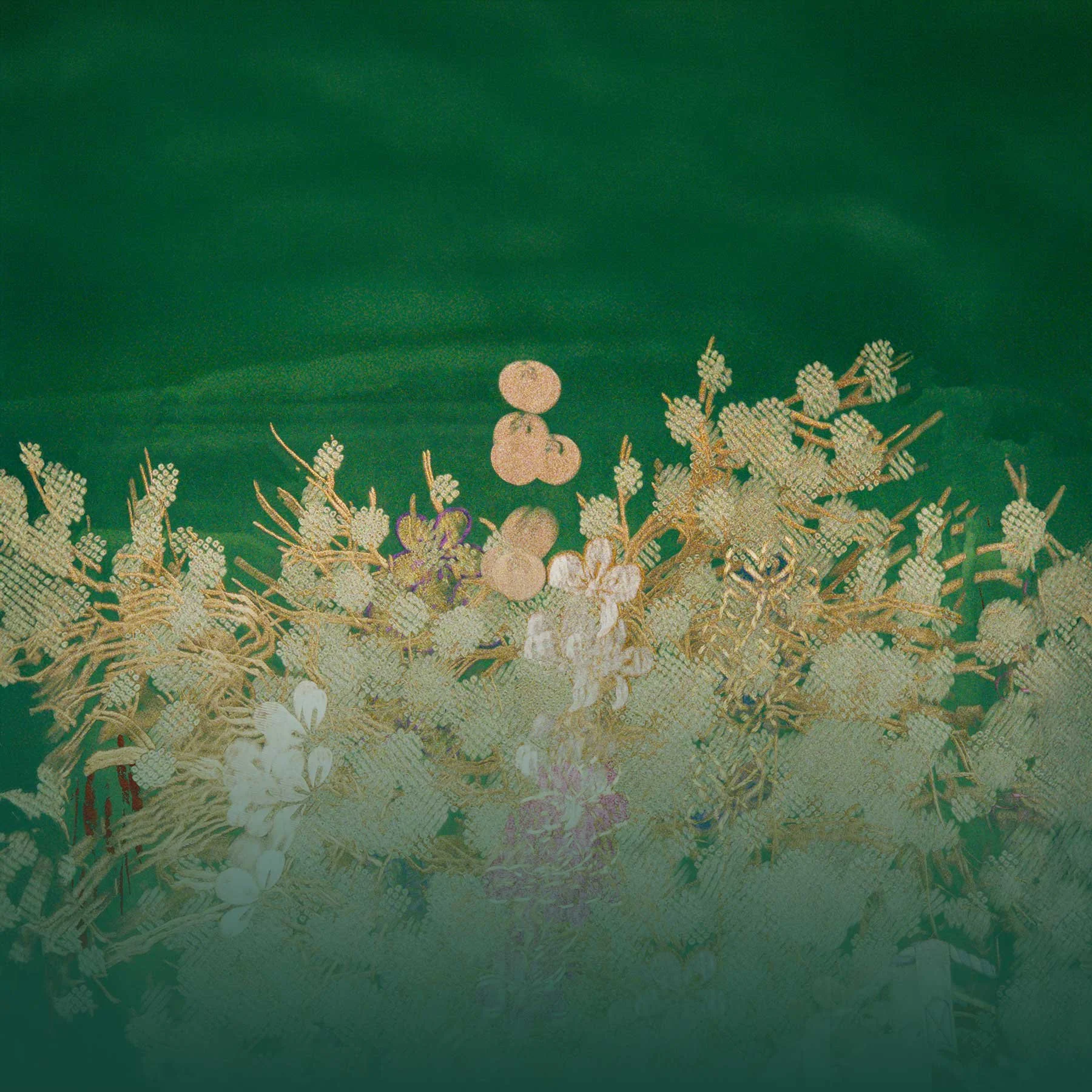 Close-up of a decorative fabric with gold floral embroidery on a green background.