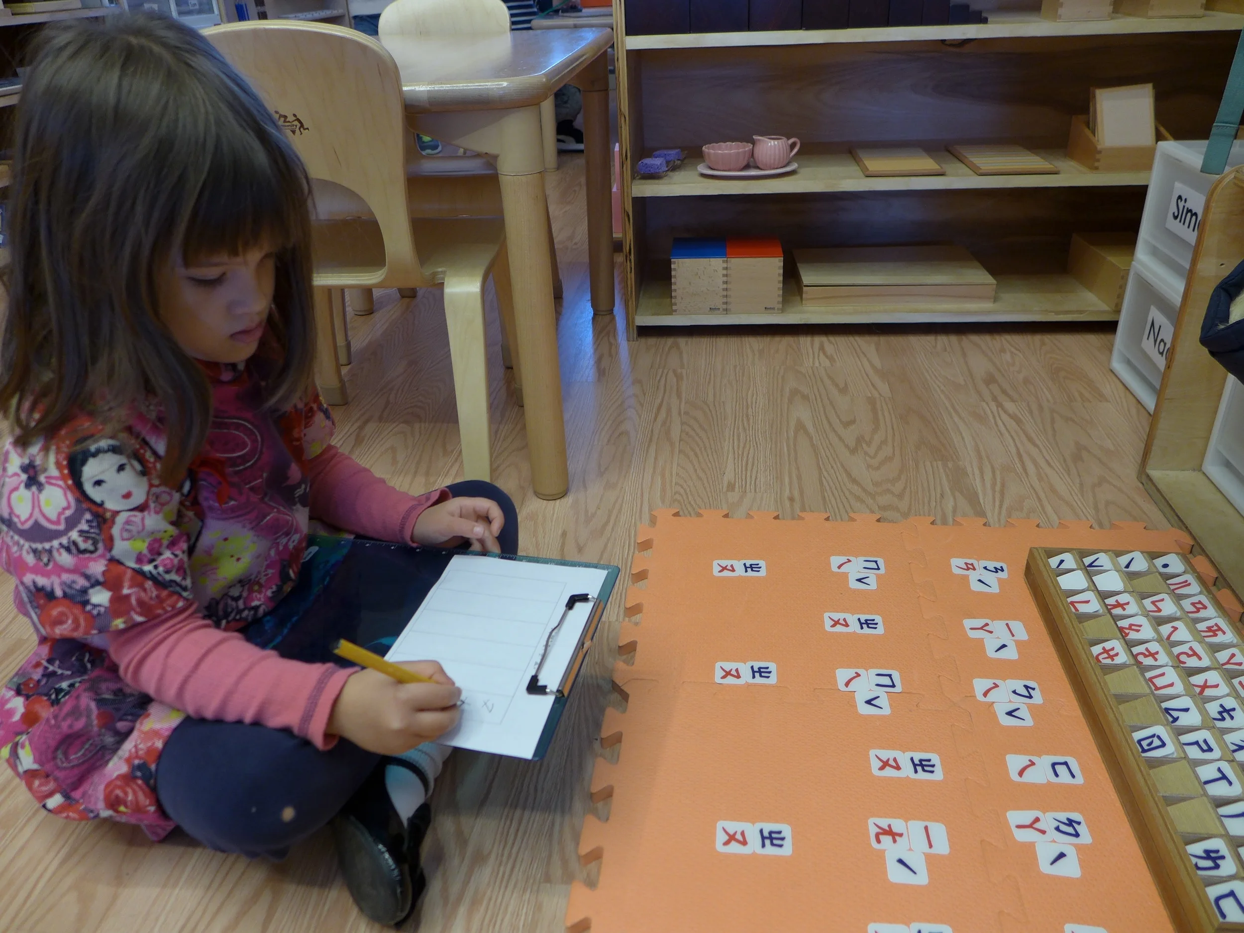 Child writing the names of the continent in Chinese