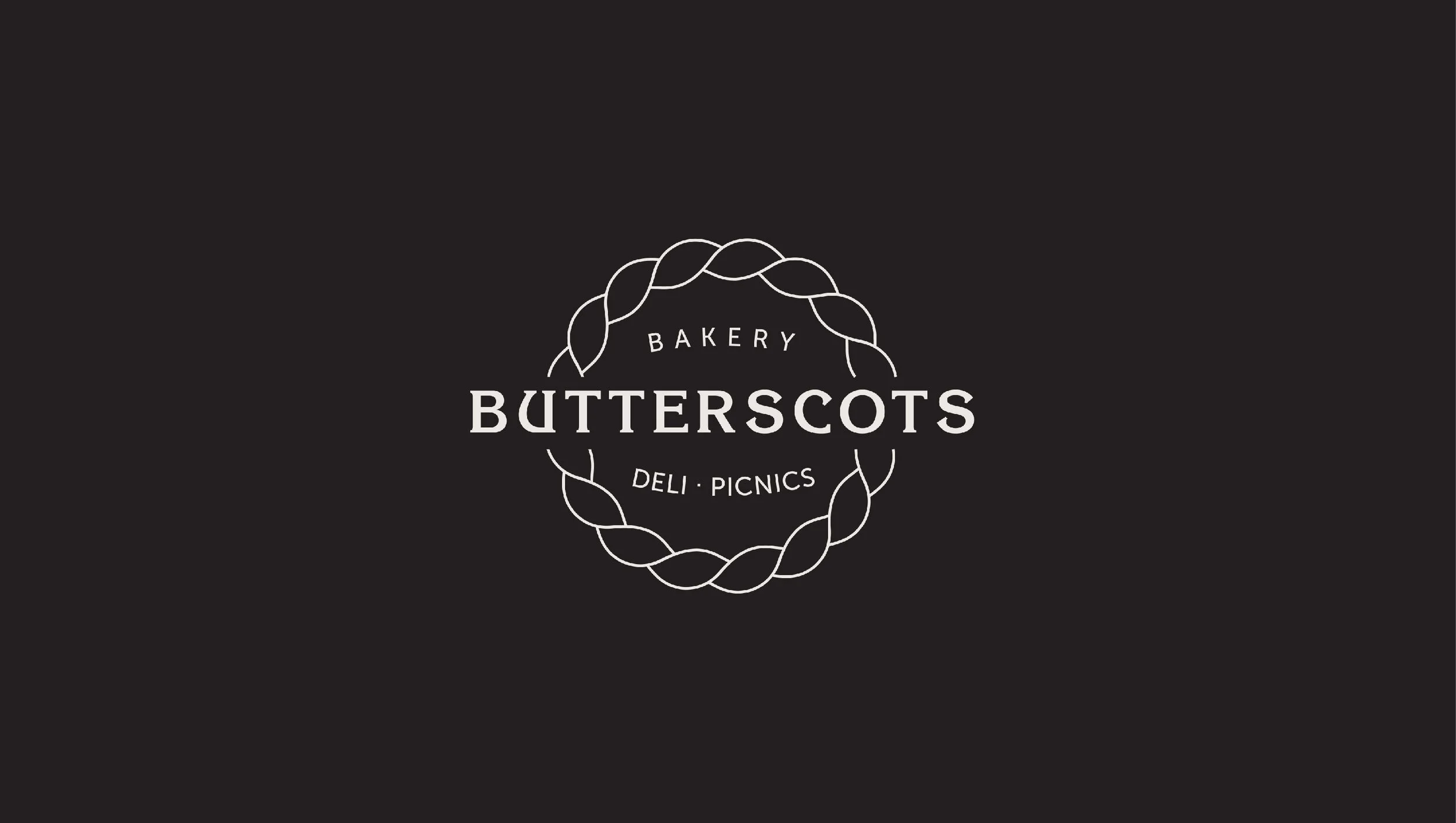 Black background with a circular logo containing a braid-like border. Inside the circle, the text reads 'BAKERY BUTTERSCOTS DELI PICNICS'.