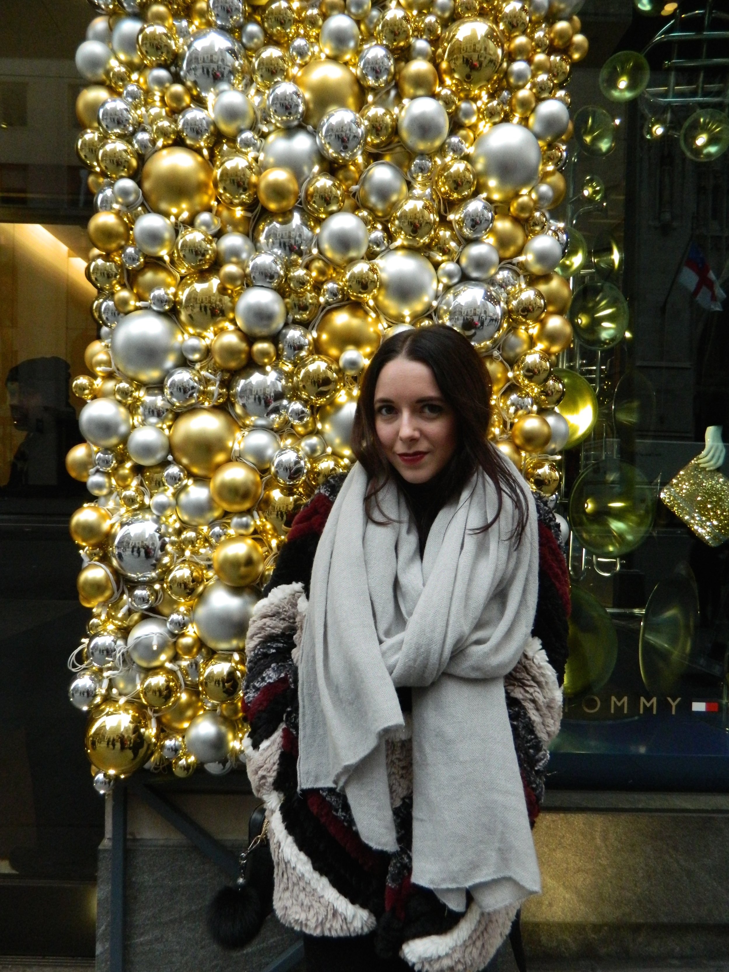 Courtney posing in front of the decadent 5th Ave store front decorations