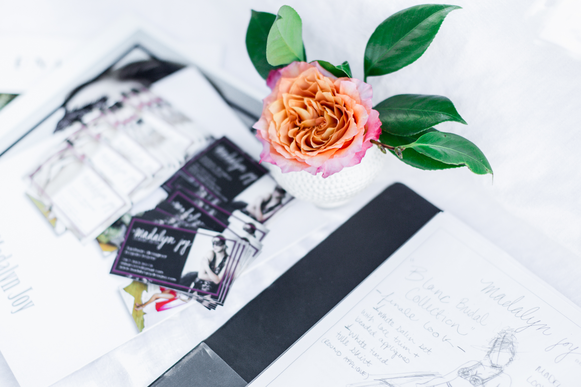 Madalyn Joy Designs business cards and sketches amidst a perfectly placed La Tulipe centerpiece. 