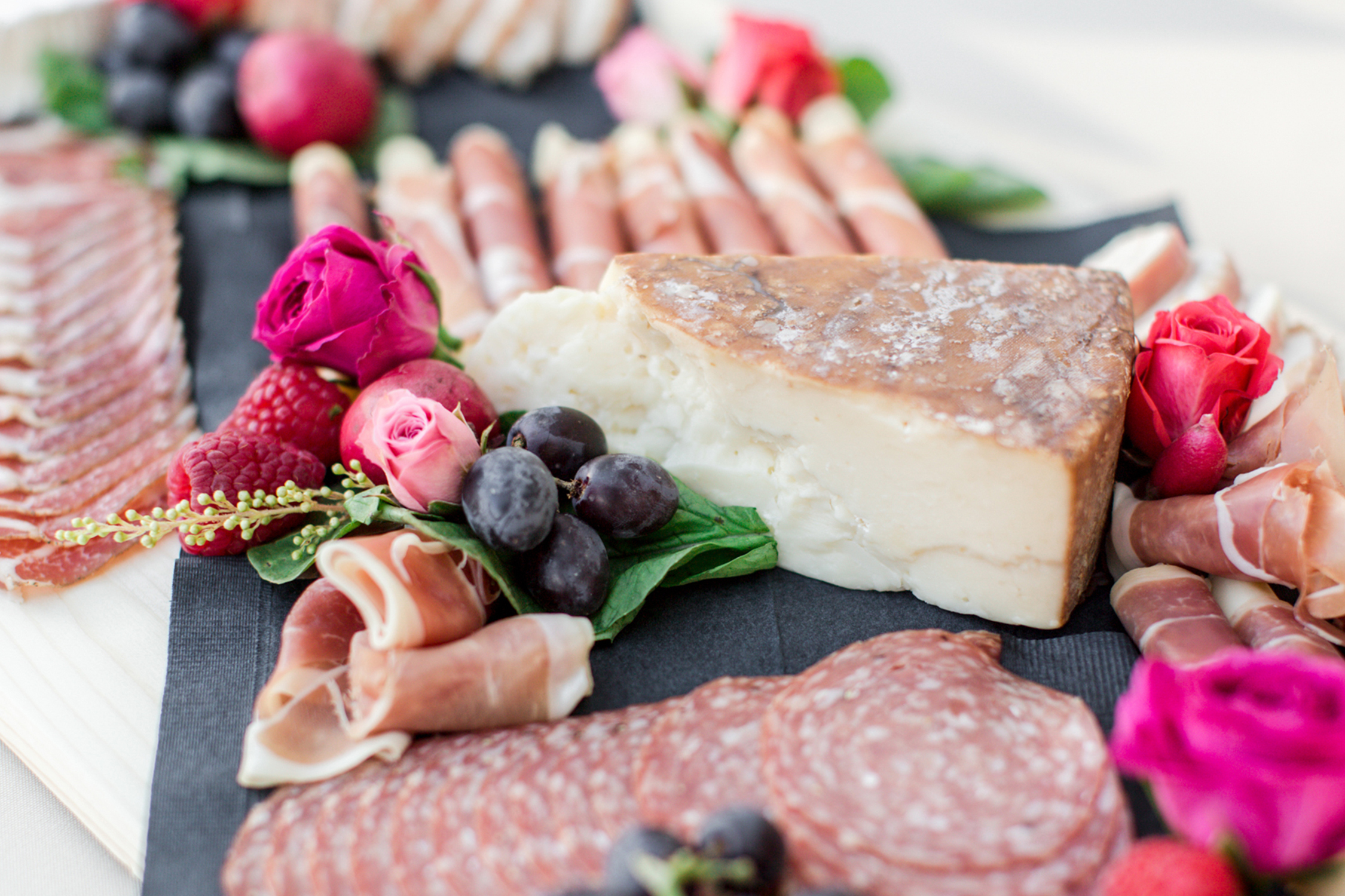 A delicious charcuterie board adorned with decadent cheeses and savory meats. 