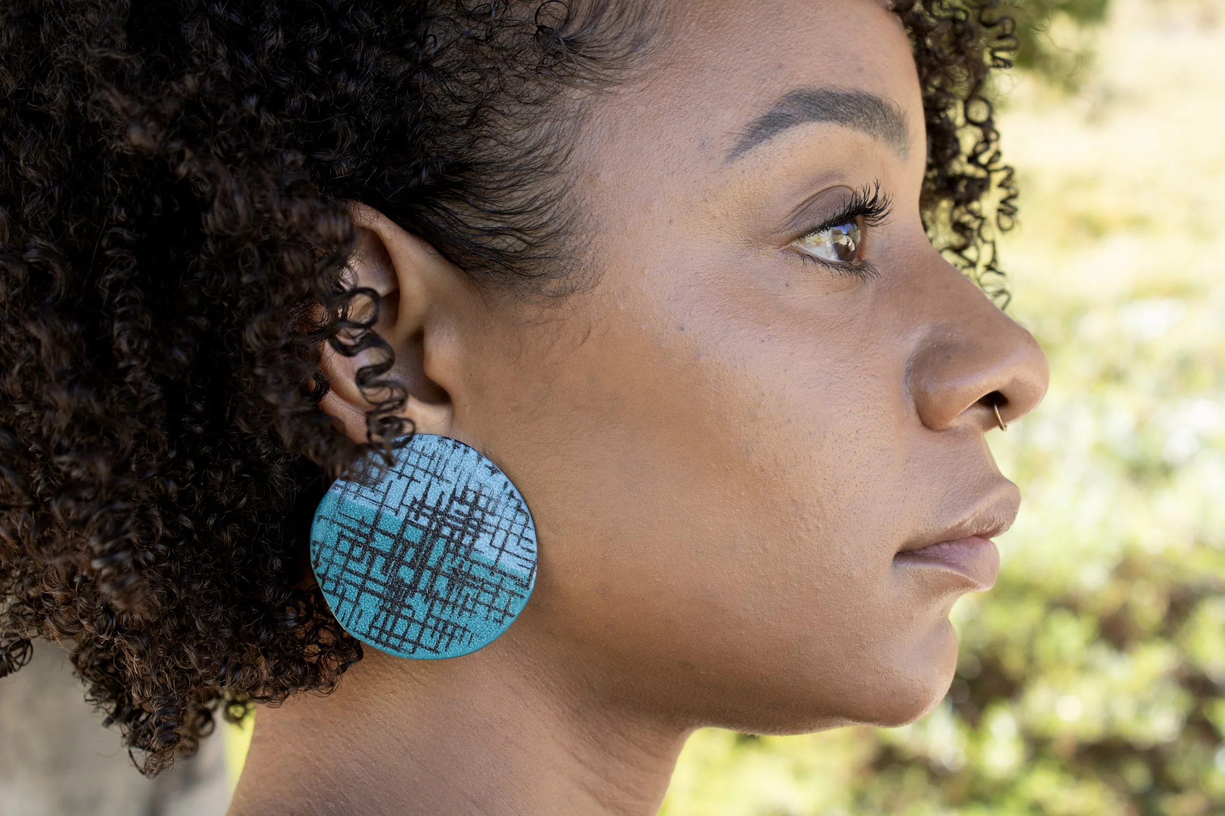 light blue and dark blue disc earrings on model