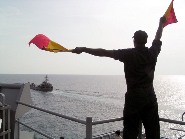 Signalman Seaman Adrian Delaney practices his semaphore aboard the amphibious dock landing ship USS Harpers Ferry (LSD 49) during an at-sea training evolution with the Royal Thai Navy tank landing ship Her Thai Majesty’s Ship (HTMS) Prathong (LST 715) during the Thailand phase of exercise Cooperation Afloat Readiness and Training (CARAT). (U.S. Navy photo by Journalist 3rd Class Alicia T. Boatwright)