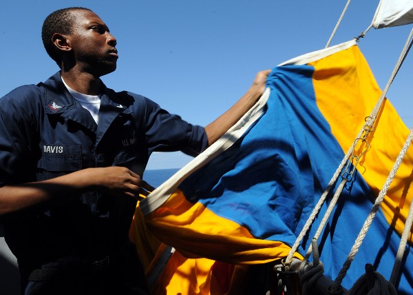 Quartermaster 3rd Class Alex Davis lowers a signal flag aboard the aircraft carrier USS George Washington (CVN 73) during a flag hoist exercise on the ship’s signal bridge. George Washington, the Navy’s only permanently forward deployed aircraft carrier, is underway supporting security and stability in the western Pacific Ocean. (U.S. Navy photo by Mass Communication Specialist Seaman Apprentice Marcos Vazquez)