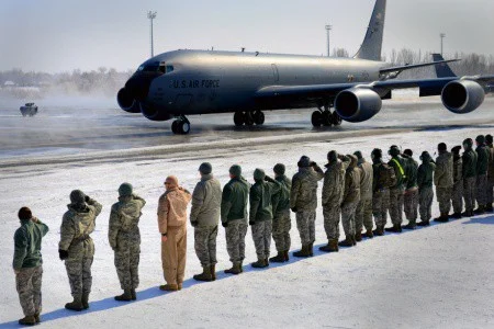 Airman salute the last KC-135 to fly combat mission from Manas taxis to park