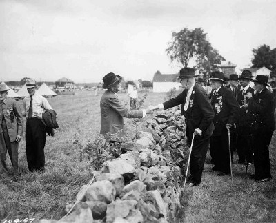 1935: At the 75th anniversary of the Battle of Gettysburg, Confederate and Union veterans shake hands across the stone wall at “the Bloody Angle,” widely regarded as the “high water mark” of the Confederacy.