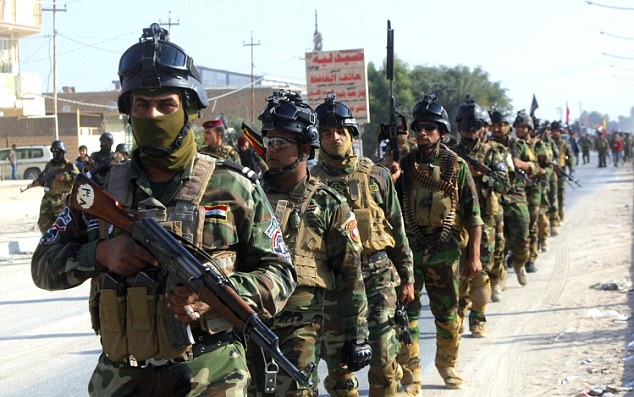 Iraqi security forces march on the outskirts of Najaf (Reuters)