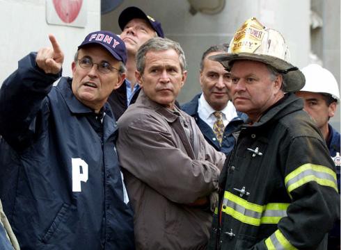 President George W. Bush, Rudy Giuliani, left, and New York Governor George Pataki, second from left, Sen. Charles Schumer, D-N.Y., second from right, and New York City Fire Commissioner Thomas Van Essen, right, look toward the fallen buildings during a tour of the World Trade Center, Friday, Sept. 14, 2001 in New York. (Doug Mills, AP)