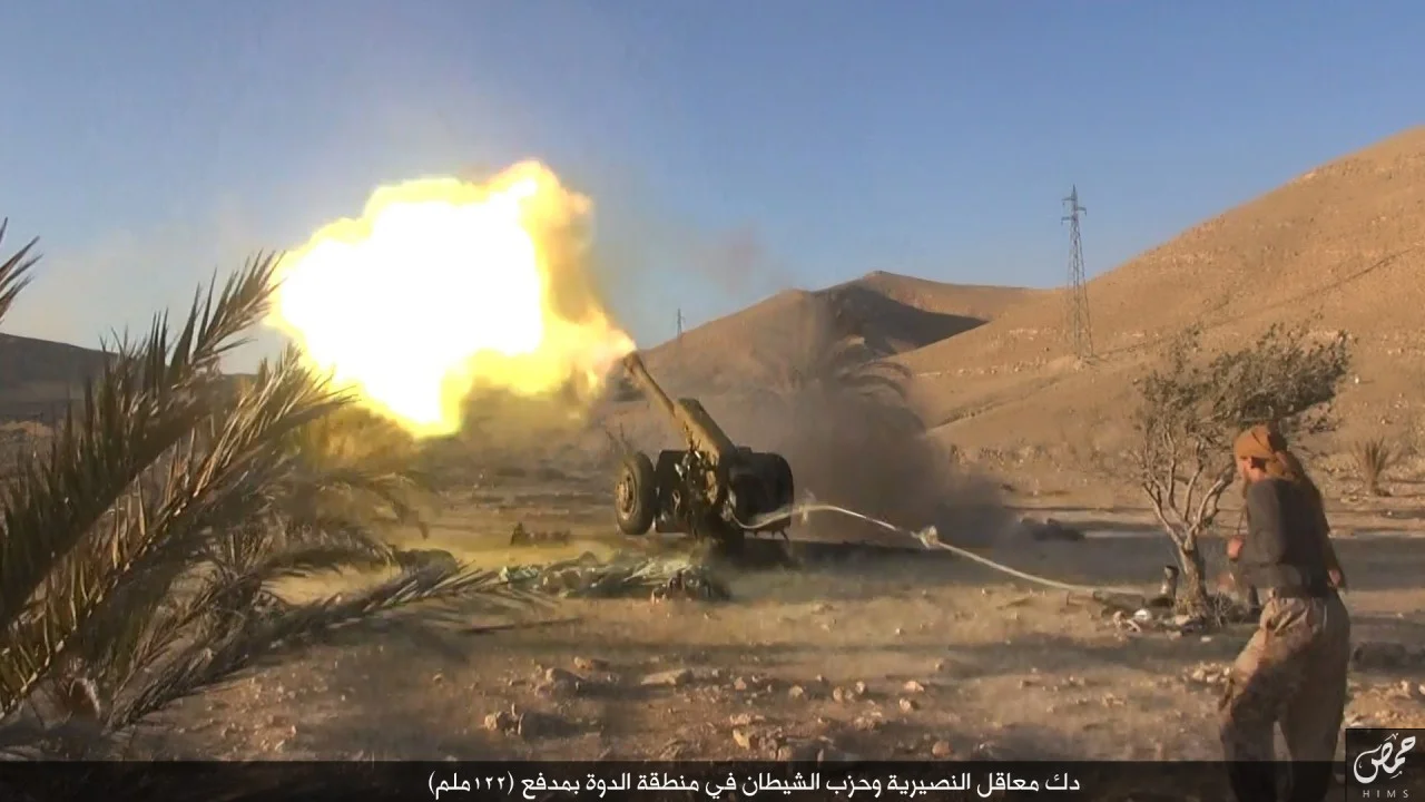 "Pounding Nusayri and Hizb Al Shaytan (party of Satan) bunkers in the Ad Dawwah region with a 122 mm cannon." Bottom right: Wilayah Homs Media Office logo.