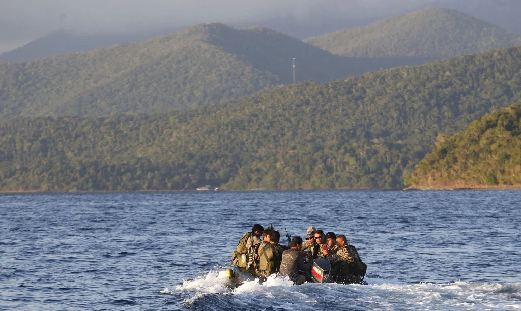 Members of the Philippine marines are transported on a rubber boat from a patrol ship after conducting a mission on the disputed Second Thomas Shoal, part of the Spratly Islands in the South China Sea, on their way to a camp in Palawan province, southwest Philippines, March 31, 2014. REUTERS/Erik De Castro