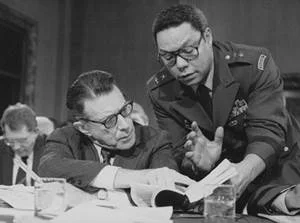 Defense Secretary Caspar Weinberger speaks with then MG Colin Powell during testimony before the Senate Budget Committee on Capitol Hill on 8 Feb 1985.