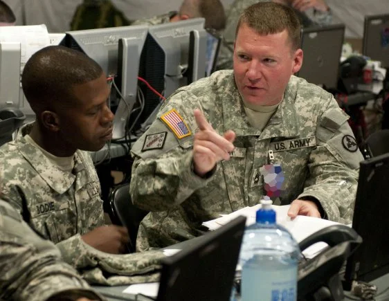 Sergeant First Class Johnathan Bodie and Timothy Inman discuss sustainment operations during the 3d Sustainment Command (Expeditionary) Command Post Exercise-Sustainment at Fort Lee, Va. ( U.S. Army photo )