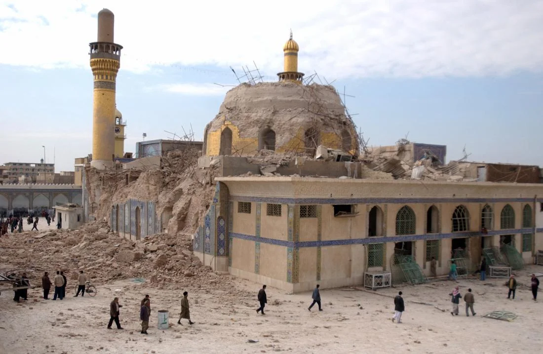 Iraqis walk past the damaged al-Askari mosque following an explosion in Samarra, 60 miles north of Baghdad, Iraq on Feb. 22, 2006. (Hameed Rasheed/AP)