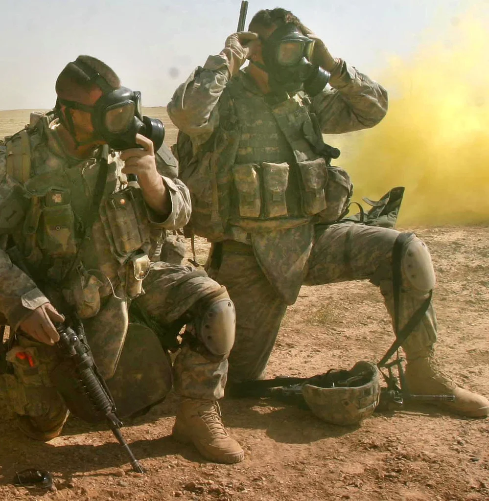 U.S. Army Soldiers put their gas masks on for a simulated chemical attack during a training mission near Camp Ramadi, Iraq, Sept. 25, 2007. ( U.S. Marine Corps photo )