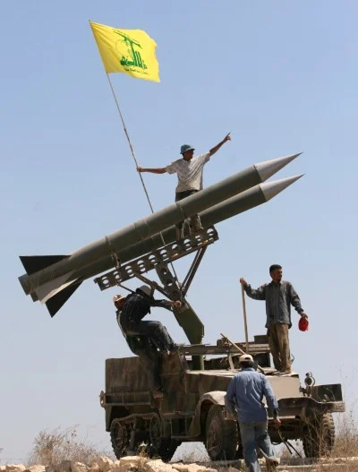 Hezbollah supporters fix the party's flag on top of their rockets near the southern port city of Tyre, Lebanon (Mohammed Zaatari / AP)
