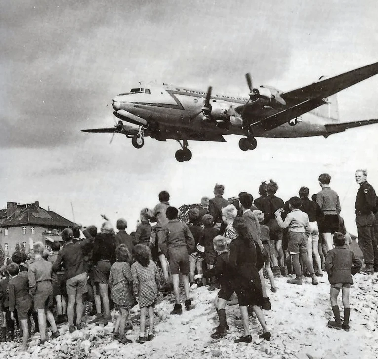 Berliners watch a Douglas C-54 Skymaster land at Tempelhof Airport, 1948 ( Wikimedia Commons )