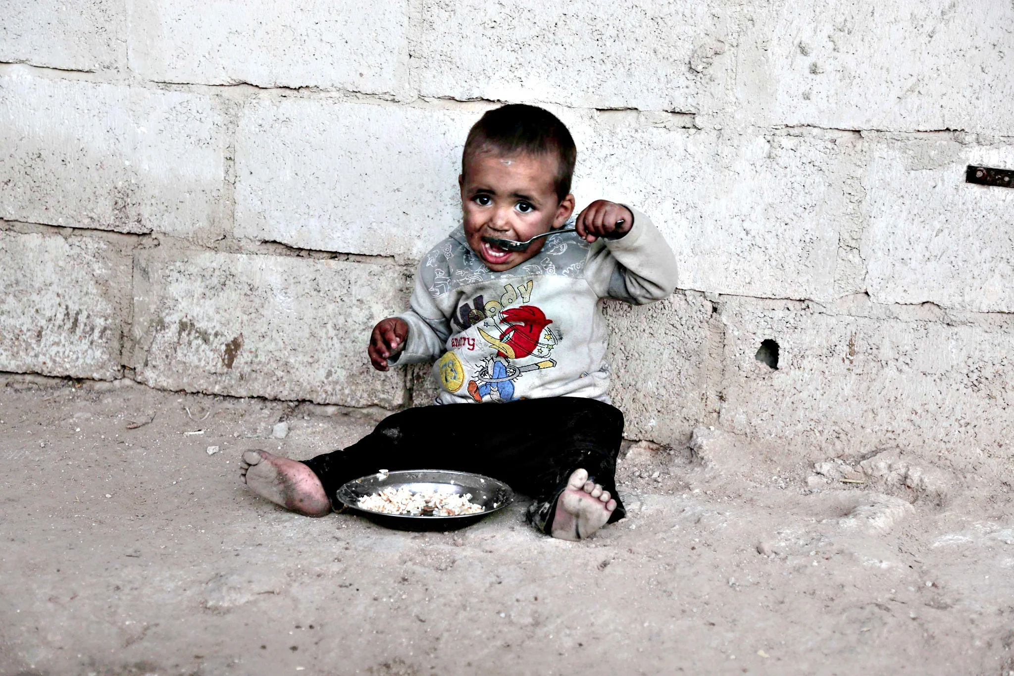 A child from the Abu Sleiman family has a lunch at his house in the Syrian town of Beit Nayem, in the rebel-held Eastern Ghouta region on the outskirts of the capital Damascus, January 14, 2016 (Photo: AFP/Amer Almohibany)