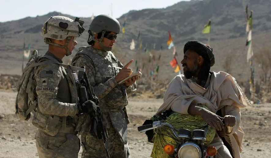 U.S. Army Sgt. Skyler Rosenberry of Pennsylvania (left) and an interpreter speak to an Afghan man in a village in Afghanistan. (AP)