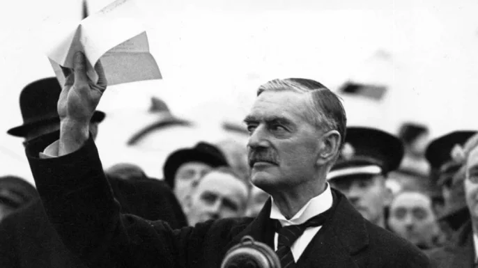 Prime Minister Neville Chamberlain upon his return to London on September 30, 1938. This representation of appeasement and "peace in our time" has become iconic...but does the analogy hold? (History.com)