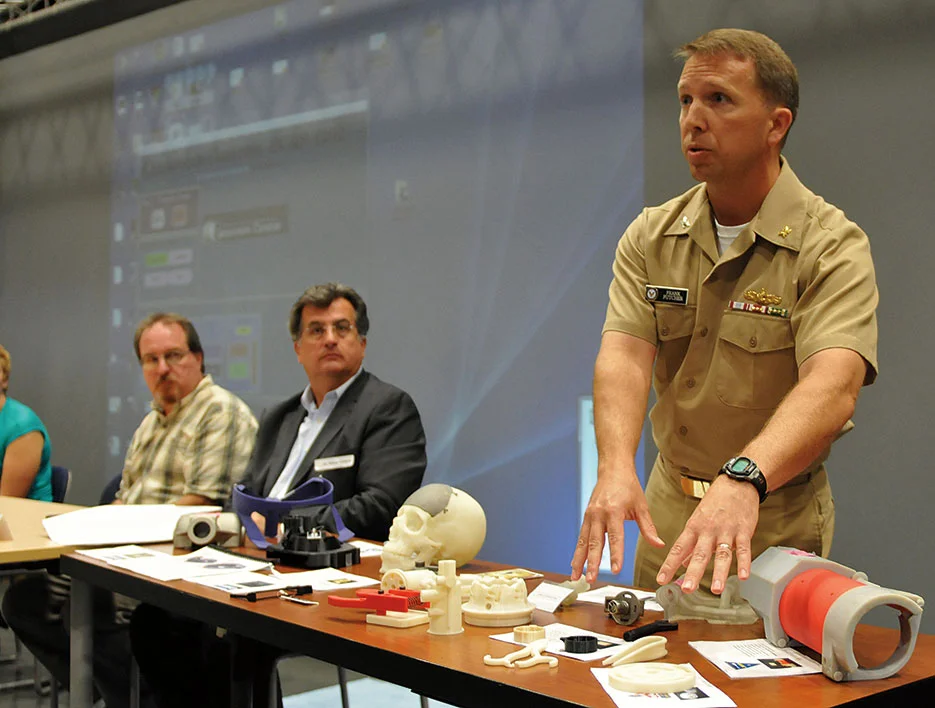 Captain Frank Futcher explains display of 3D-printed objects during Navy Warfare Development Command–sponsored innovation workshop at Old Dominion University in Norfolk, Virginia (Jonathan E. Donnelly/U.S. Navy Photo)