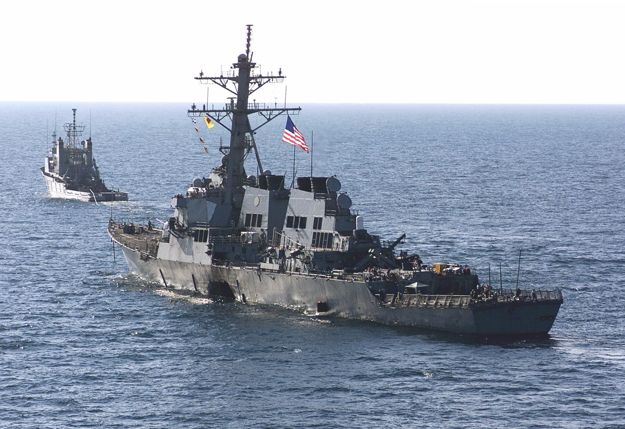 The USS Cole towed away from the port city of Aden, Yemen, into open sea by the tug USNS Catawba. (Sgt. Don L. Maes/USMC Photo)