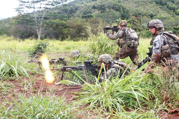 Spc. Derrick Penninger (center, foreground), infantryman, Troop C, 3rd Sqdn., 4th Cav. Regt., 3rd BCT, 25th ID,, fires a burst from his M240B machine gun as his squad engages an enemy bunker during Operation Raider Pillage, April 24 | Photo by 1st Lt. Garrett Nash, 3rd Brigade Combat Team Public Affairs, 25th Infantry Division.