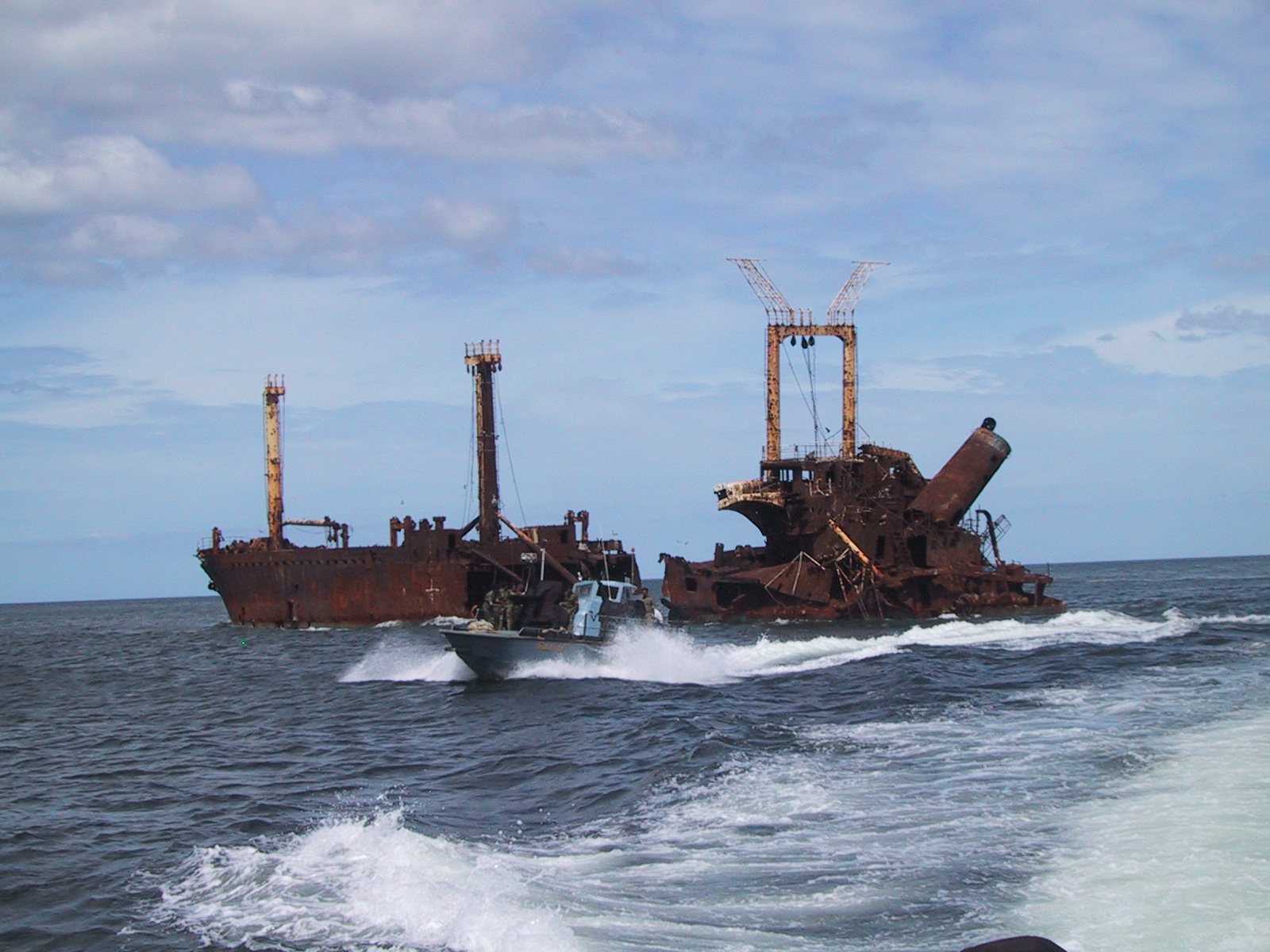An LTTE Sea Tiger fast attack fiberglass boat passing a Sri Lankan freighter sunken by the Sea Tigers just north of the village of Mullaitivu, North-eastern Sri Lanka. (Isak Berntsen/Wikimedia)