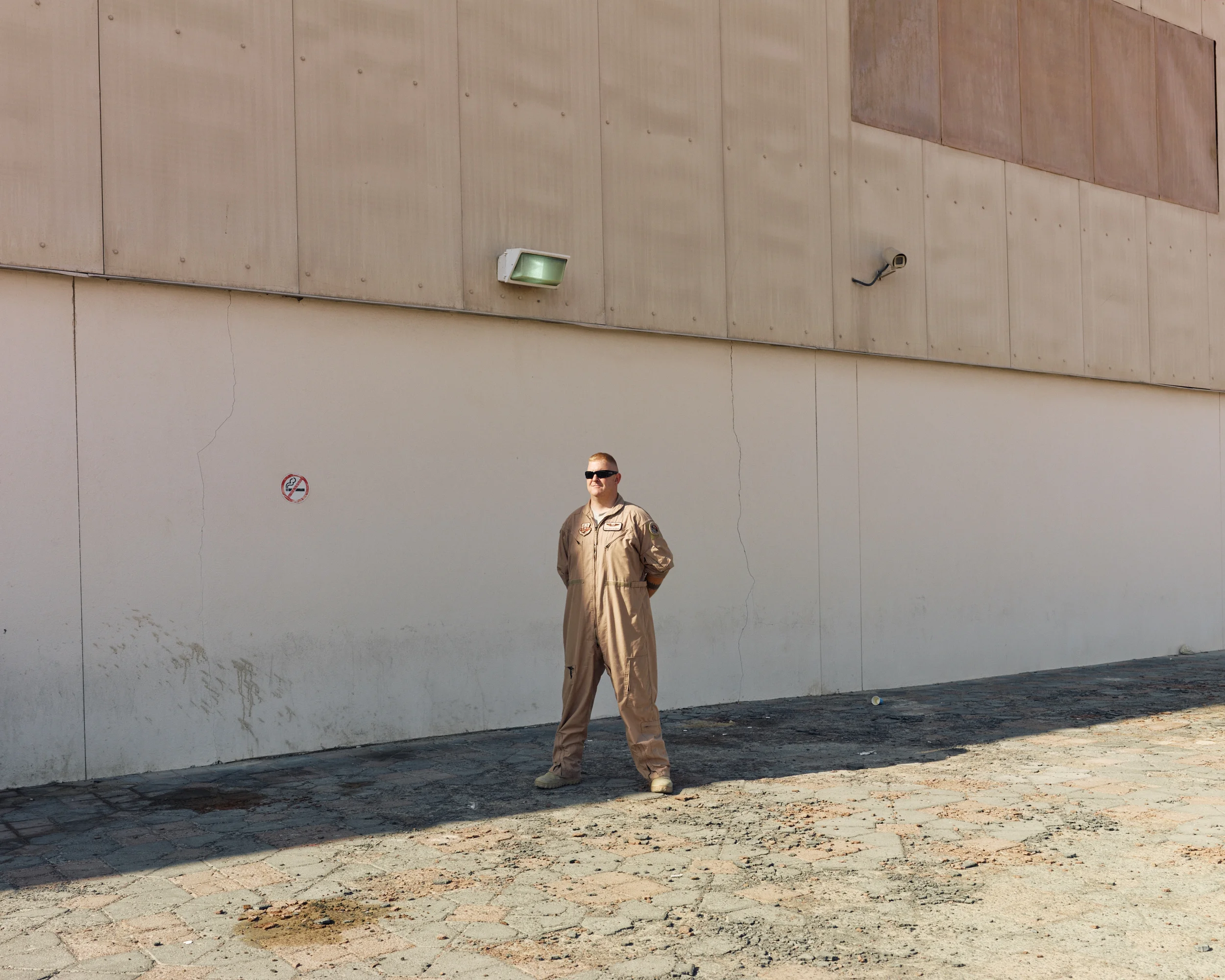 An airman stands outside a hangar at the Air Warfare Center in Al Dhafra, UAE. ( Jason Koxvold )