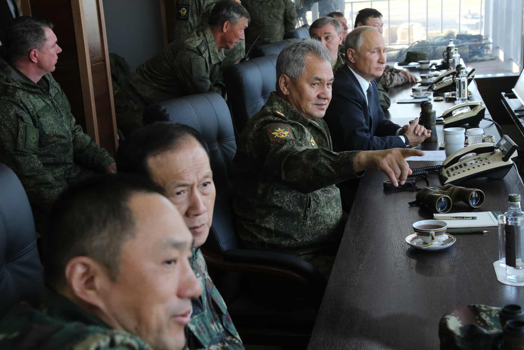   Russia’s defence minister, Sergei Shoigu, and the president, Vladimir Putin, watch the Vostok war games with military personnel (Vadim Savitsky/Tass)  