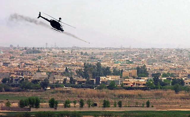 An OH-58 Kiowa helicopter fires a 17 pound rocket over the city of Mosul, Iraq. (BlackFive)