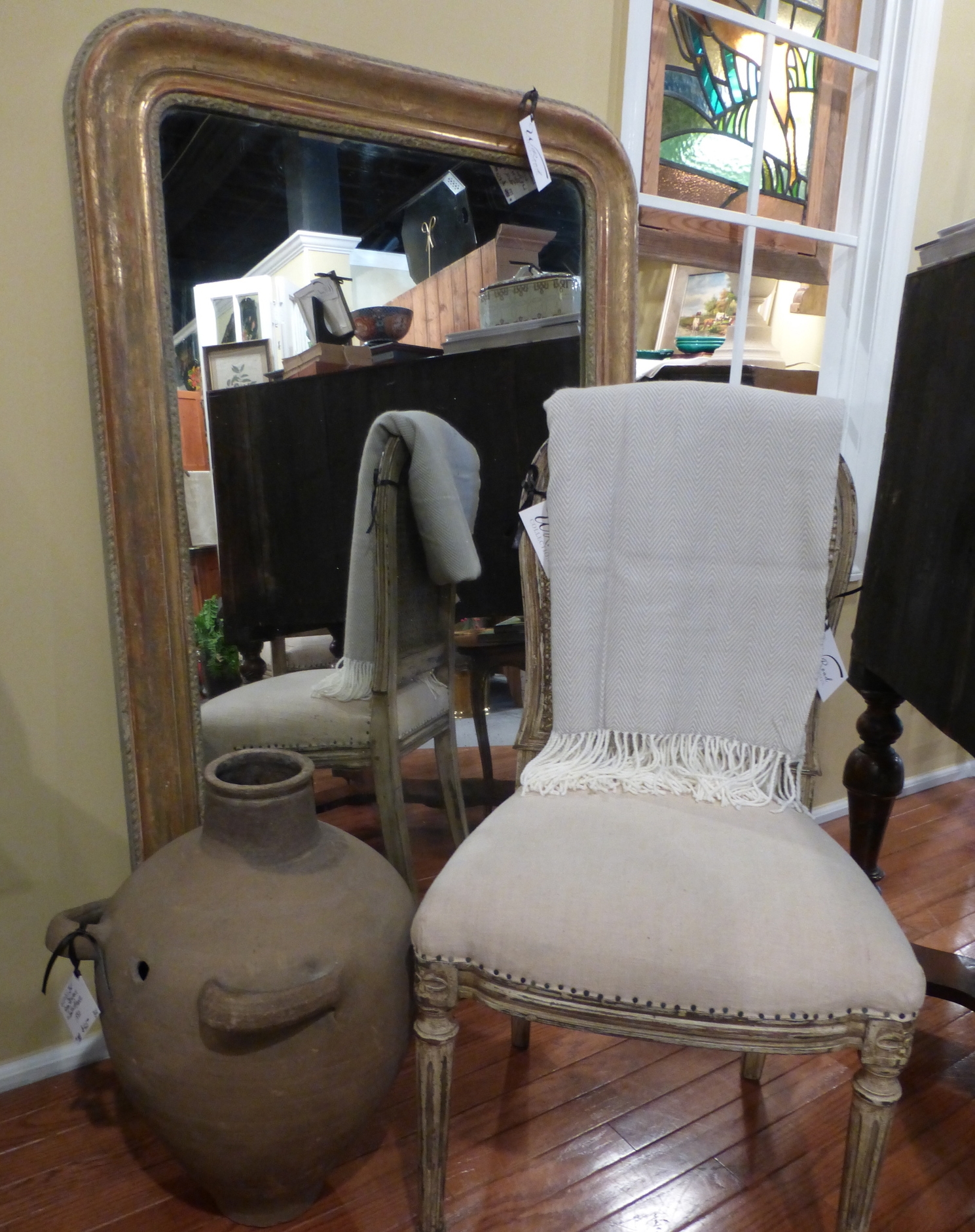 1830's Louise Philippe Mirror propped behind a mid 20th century chair in the Empire style and a 1880's Provencal jar.