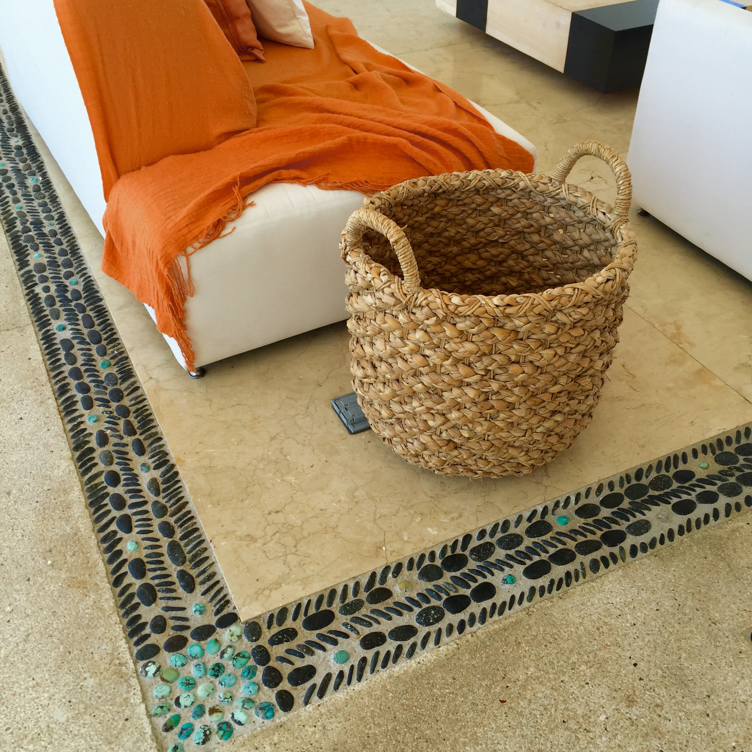 Natural woven baskets and orange and white in the main lobby.