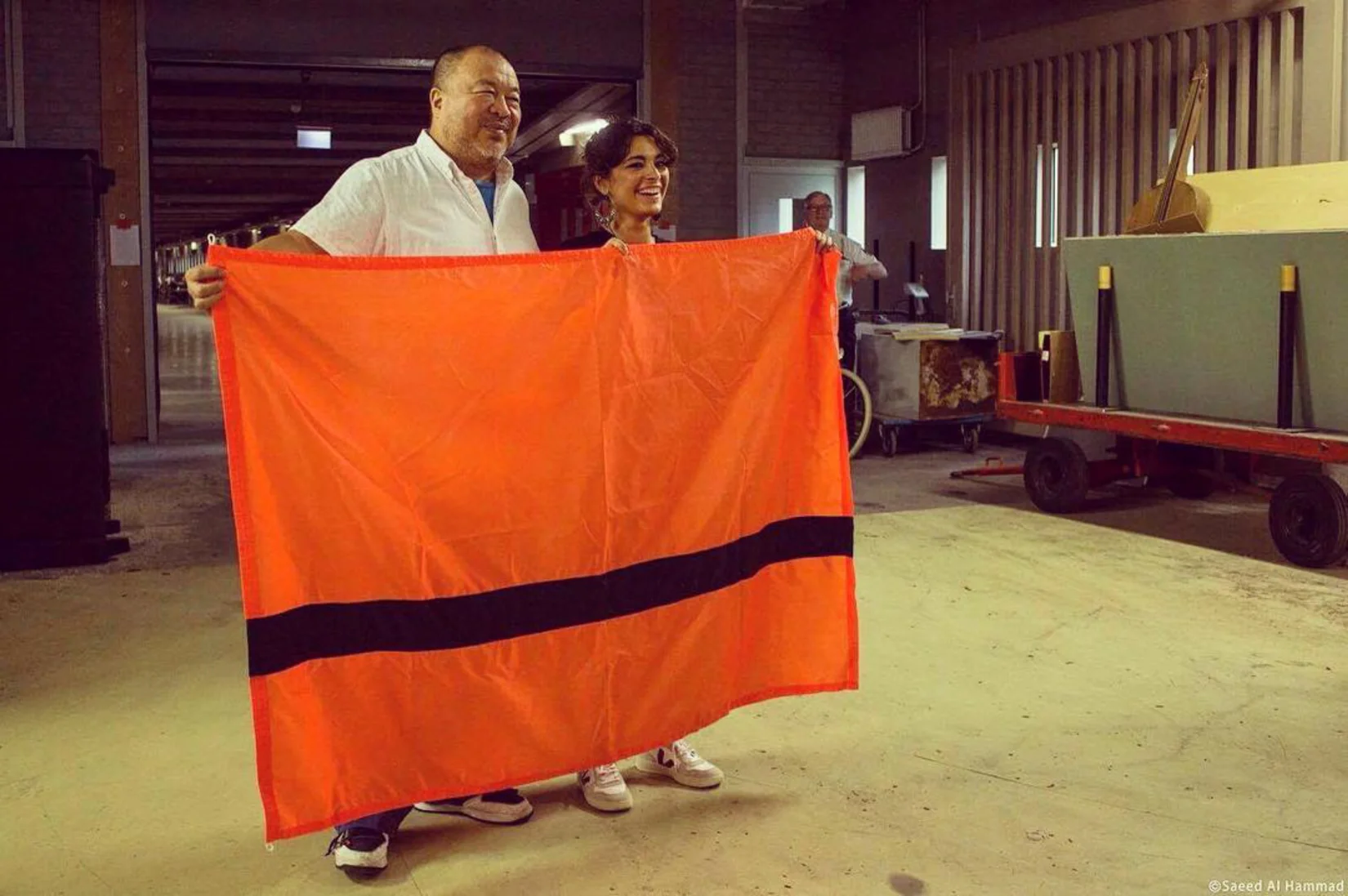 The legendary artist Ai Weiwei and dissident holding our flag next to its designer Yara Said.