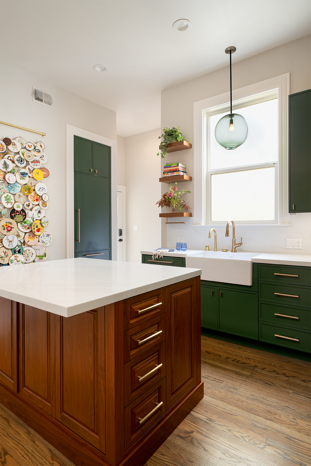 The remodeled kitchen combines classic cabinetry, saturated green color, natural wood, and warm metallic finishes for a modern update that feels at home in its San Francisco setting.