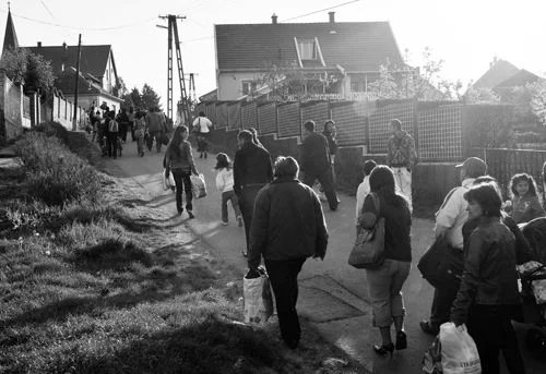 Roma carry their possessions through the village of Gyongyospata, eastern Hungary, Friday, April 22, 2011. Roma leaders say they have evacuated 277 women and children from a village in Hungary because a far-right vigilante group is setting up a training camp near their homes. (AP Photo/Bela Szandelszky)