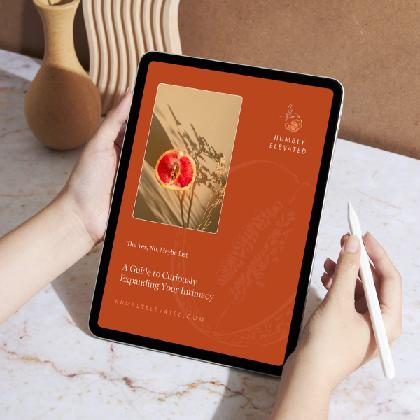 Person holding a tablet displaying a book cover titled 'A Guide to Curiously Expanding Your Intimacy' from Humbly Elevated, featuring an image of a peach with a digital effect.