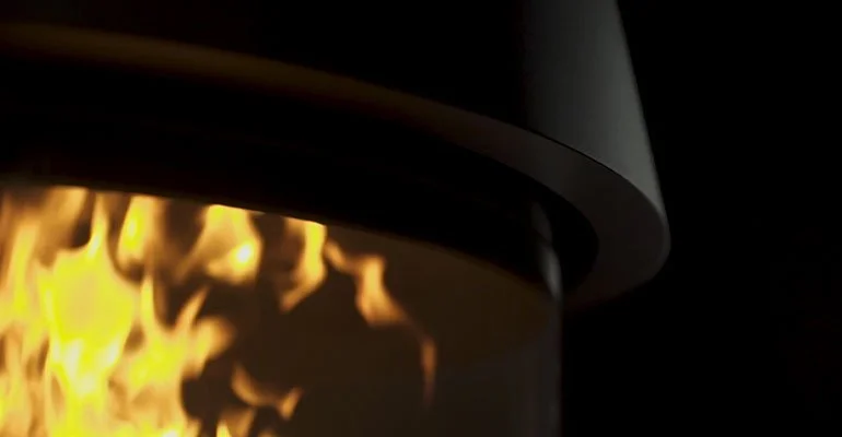 Close-up of a fireplace with visible flames and a chimney pipe at the top.