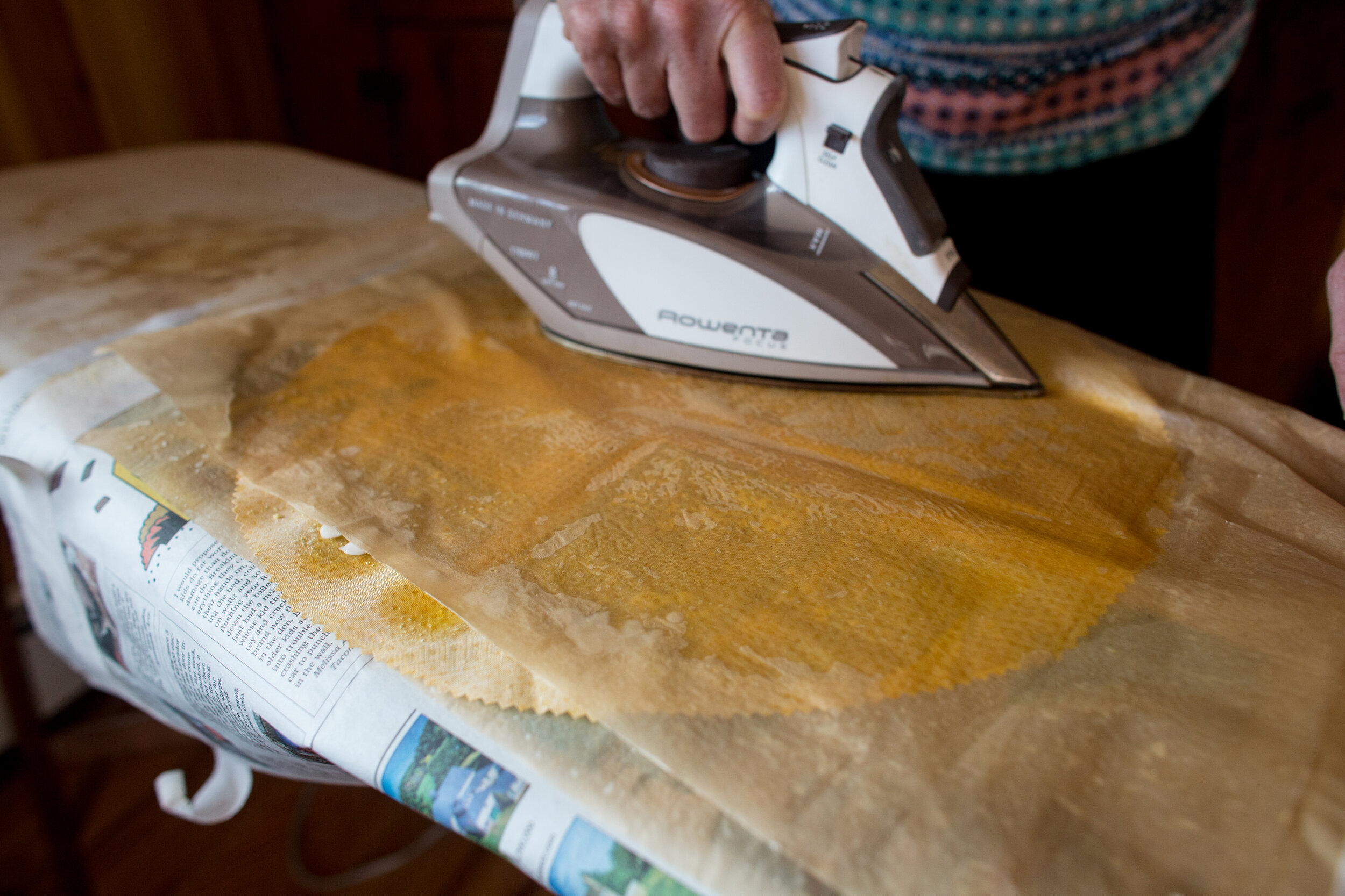 With a hot iron, press the fabric between the layers of parchment