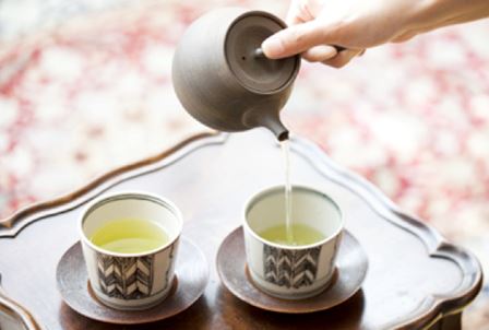 Green tea carefully brewed in a small teapot.