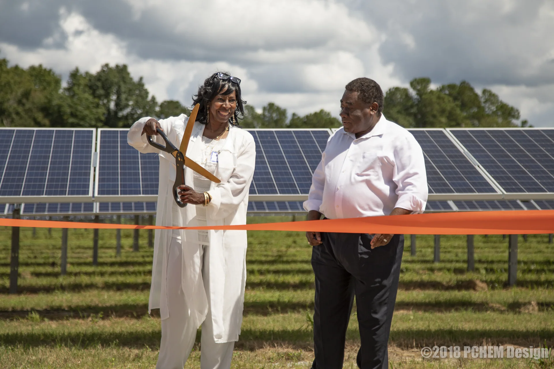 Loretta Slater, with Rev. Leo Woodberry, prepares for the ribbon-cutting to dedicate the Solar Facility to her daughter.