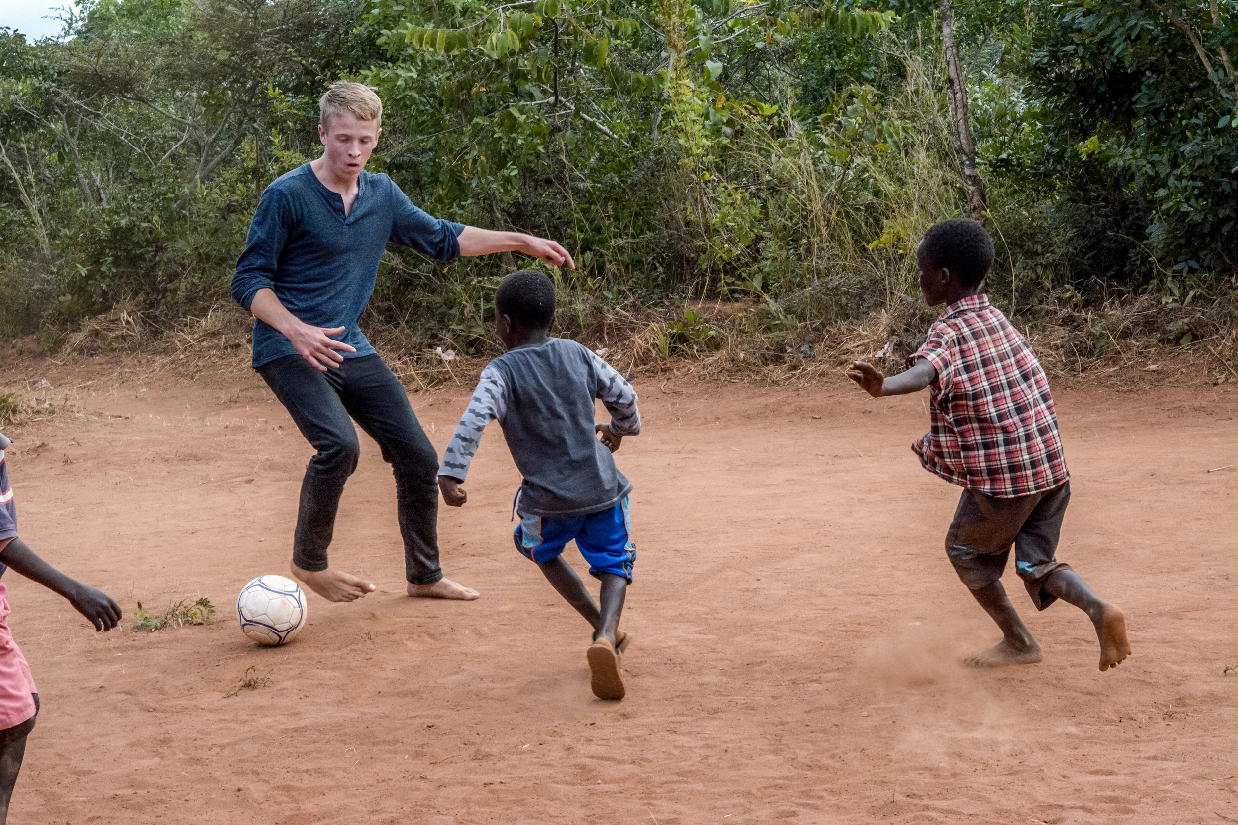 A photo of me playing soccer with the children in Viweme Village, Malawi.