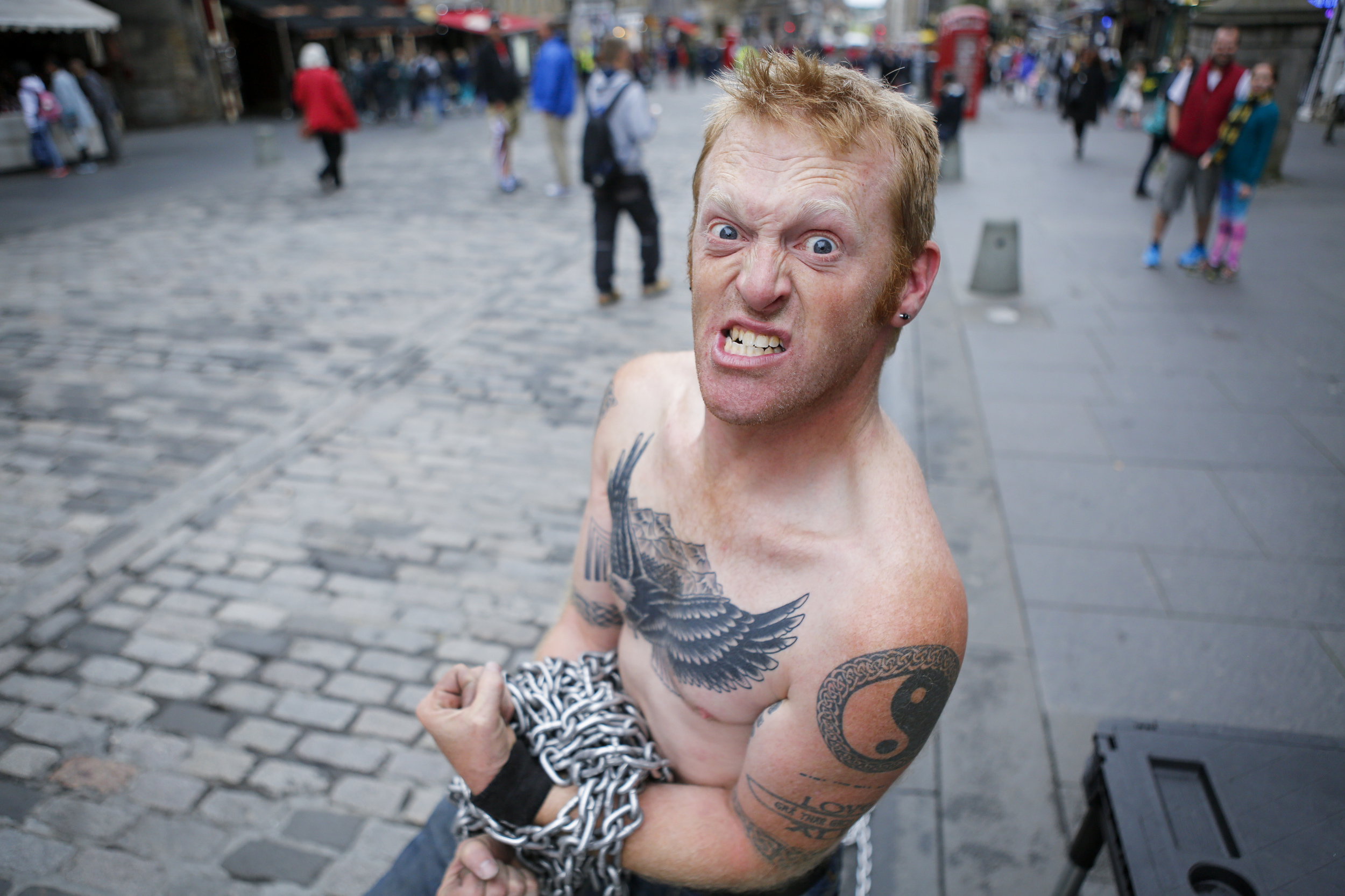  "Todd Various," an Edinburgh-based street performer originally from Detroit, flexes for a portrait on the Royal Mile in Edinburgh on July 20, 2015. 