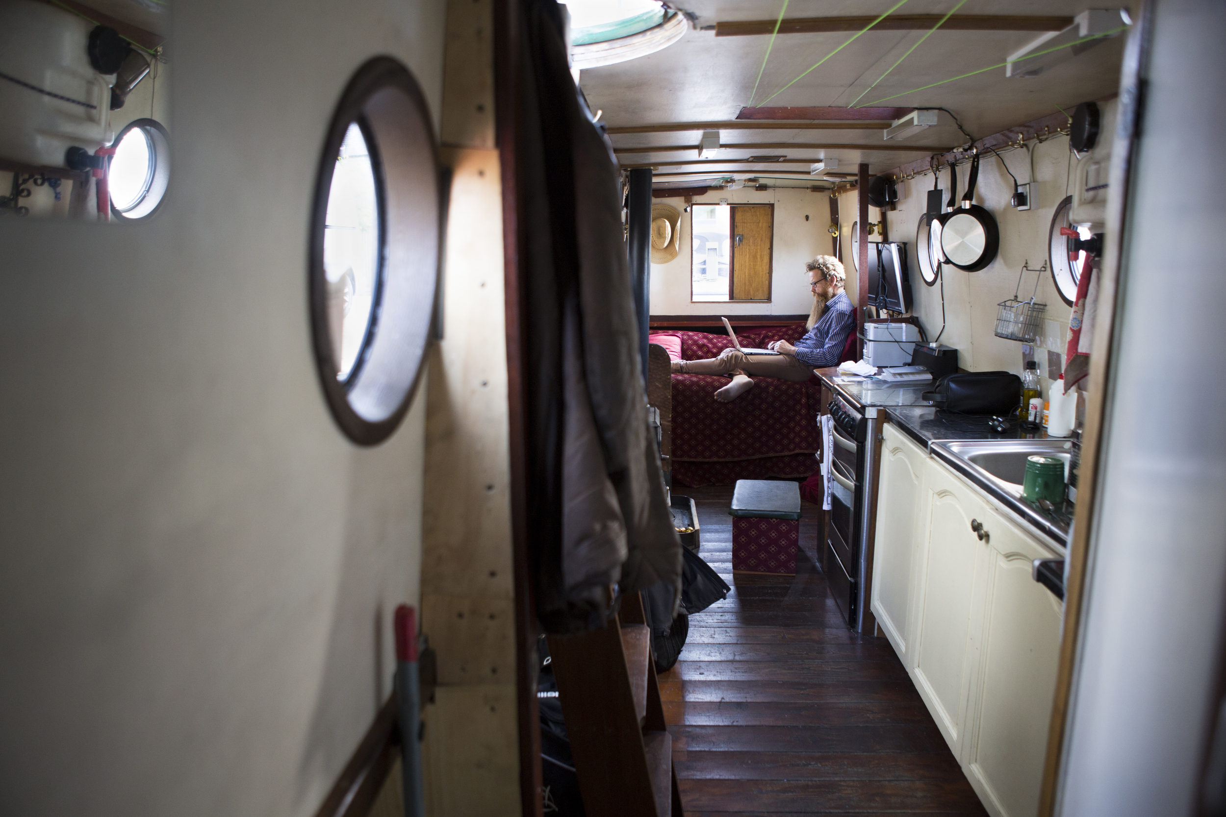  Nic Boyes works on his laptop in his houseboat along the Union Canal in Edinburgh, Scotland on August 1, 2015. Boyes has lived in a houseboat for several years and said he likes the freedom it affords him in moving around. 
